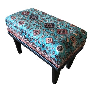 a colorful, patterned ottoman or footstool with a blue and orange floral design.