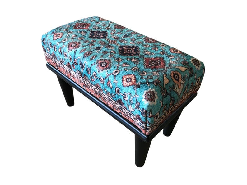 a colorful, patterned ottoman or footstool with a blue and orange floral design.