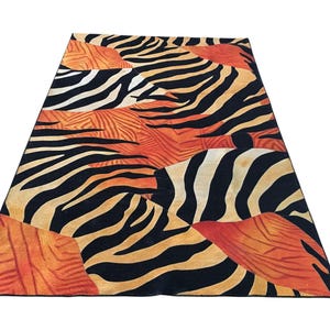 a vibrant and bold zebra print rug with a striking combination of orange, black, and white stripes.