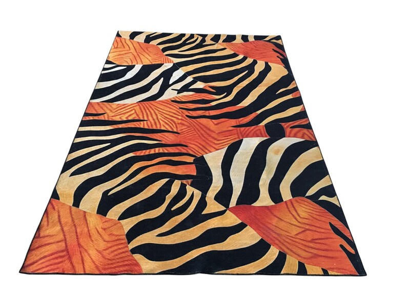 a vibrant and bold zebra print rug with a striking combination of orange, black, and white stripes.
