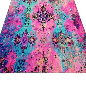a vibrant, colorful rug with intricate patterns and designs in shades of pink, blue, and green.