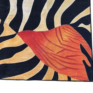 a close-up view of a vibrant, abstract pattern with bold stripes in shades of orange, black, and white.