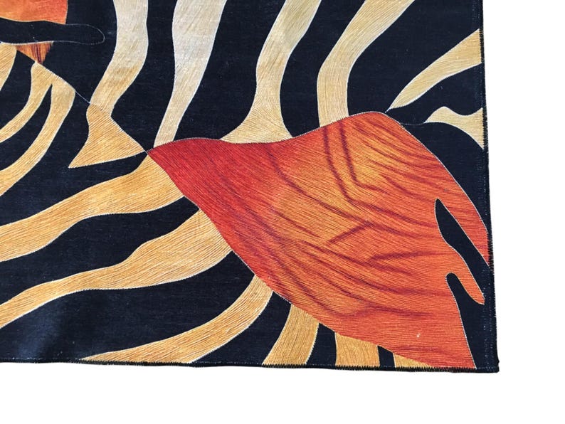 a close-up view of a vibrant, abstract pattern with bold stripes in shades of orange, black, and white.