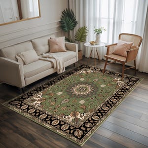 a cozy living room with a large green and black patterned rug, a beige sofa, a wooden chair, and a small table with a vase of flowers.