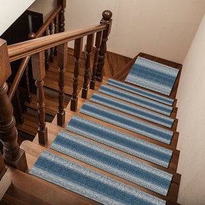 Pode incluir: Um conjunto de degraus de escada listrados em azul e branco. Os degraus são feitos de um material macio e texturizado e são projetados para ajudar a prevenir escorregões e quedas.