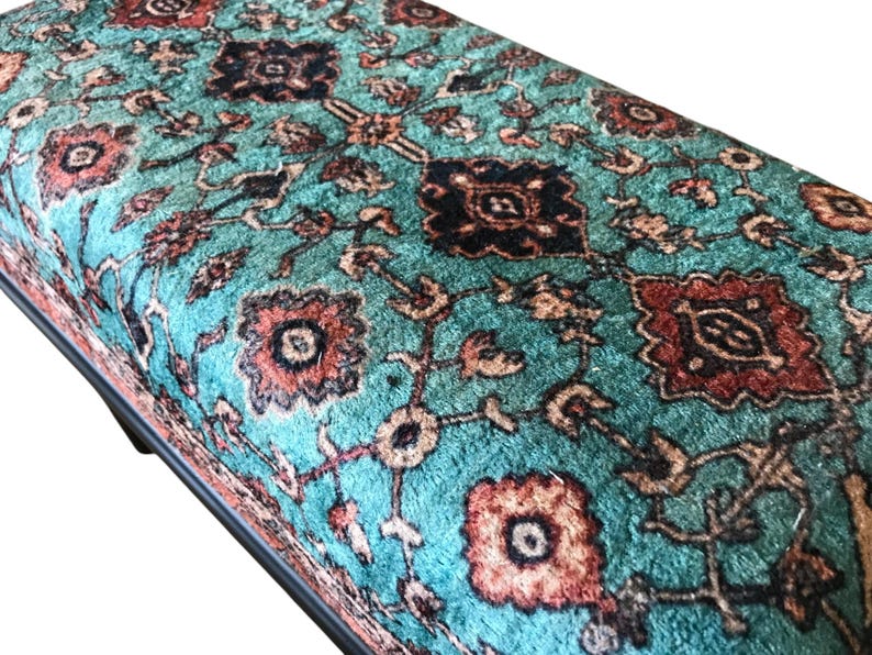 a close-up view of a vibrant, intricately patterned rug or carpet with a mix of geometric and floral designs in shades of blue, red, and orange.