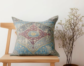 May include: A decorative throw pillow with a blue, red, and gold patterned design. The pillow is sitting on a wooden chair.