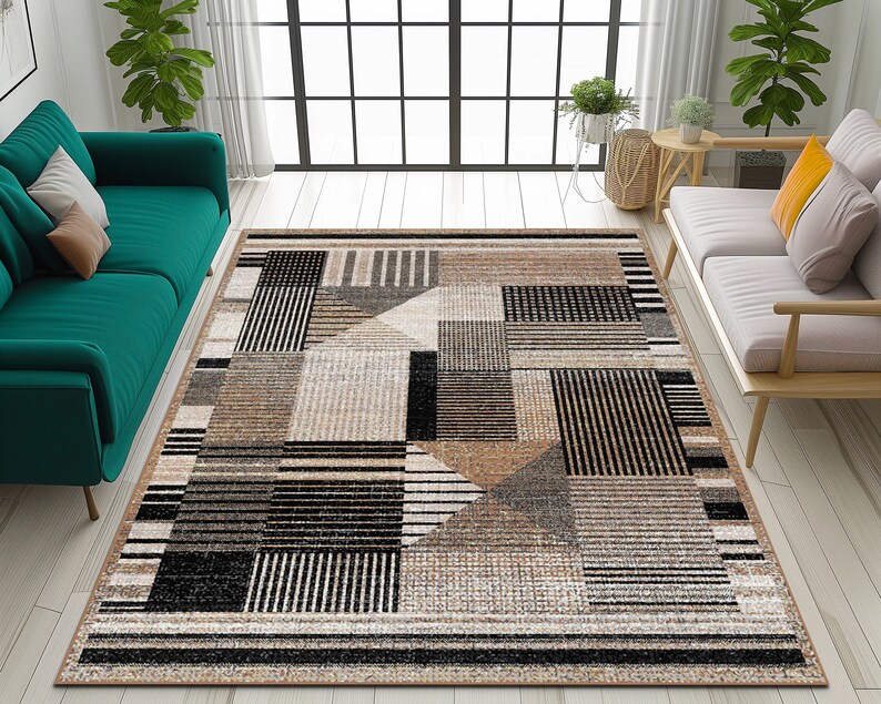 Op de afbeelding: Een geometrisch patroon tapijt met zwarte, bruine en beige strepen en vierkanten. Het tapijt ligt op een lichte houten vloer in een woonkamer.
