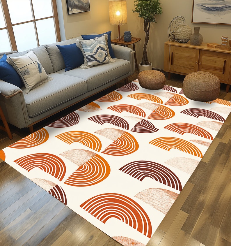 May include: A white area rug with a geometric pattern of orange and brown semi-circles. The rug is on a hardwood floor in a living room setting.
