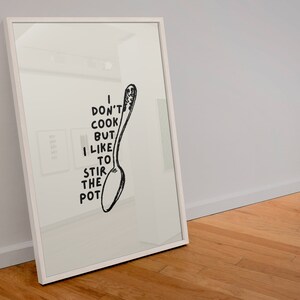 May include: A white framed print with a black and white illustration of a spoon and the text "I don't cook but I like to stir the pot."