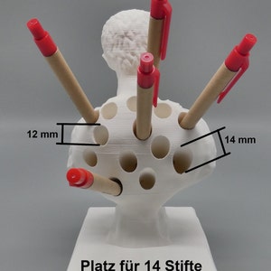 K&ouml;nnte beinhalten: Wei&szlig;er Plastik-Stiftst&auml;nder in Form einer B&uuml;ste mit 14 L&ouml;chern f&uuml;r Stifte. Die L&ouml;cher sind 12 mm breit und 14 mm tief. Der St&auml;nder hat den Text "Platz f&uuml;r 14 Stifte" auf der Basis.