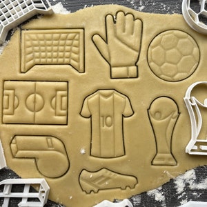 stampino per biscotti, pallone da calcio, coppa, scarpetta, maglia, porta, campo, fischietto, guanto; Set tagliabiscotti 8 pezzi.