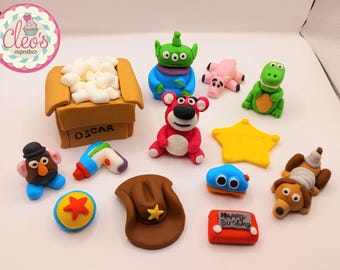 Könnte beinhalten: Eine Sammlung farbenfroher, handgefertigter Fondant-Kuchenaufsätze mit Figuren aus dem Animationsfilm Toy Story. Enthält eine Popcorn-Box, einen Cowboyhut, einen Stern und verschiedene Figuren.
