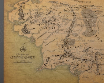 Puede incluir: Un mapa de estilo vintage de la Tierra Media de El Señor de los Anillos. El mapa está impreso en un lienzo con un fondo marrón y presenta los nombres de varios lugares, incluyendo Mordor, Rohan y la Comarca.