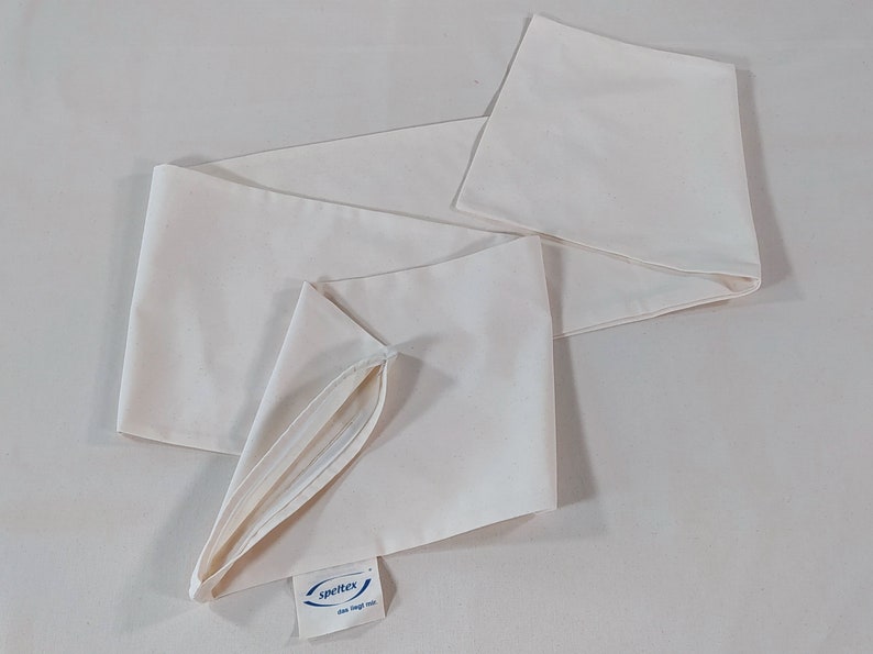 May include: A white cotton pillowcase with a zipper opening. The pillowcase has a small blue label with the text "Spritex one size fits all".