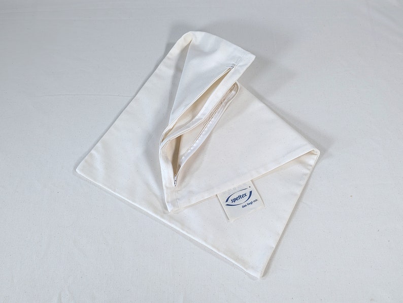 May include: A white canvas zippered tote bag with a blue logo that says "SpeltEx" and "draw string bag mini".