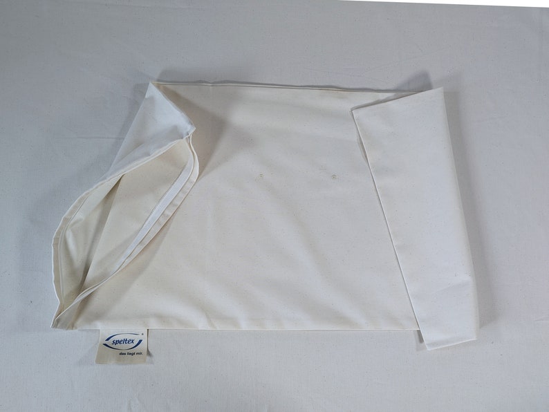 May include: A white pillowcase with a blue and white label that says "speltex" and "down duvet fill".