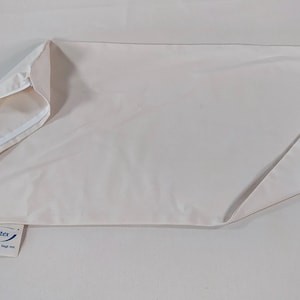 May include: A white pillowcase with a zipper closure. The pillowcase is made of a soft, breathable fabric. The brand name "Spettex" is printed on a blue tag attached to the pillowcase.