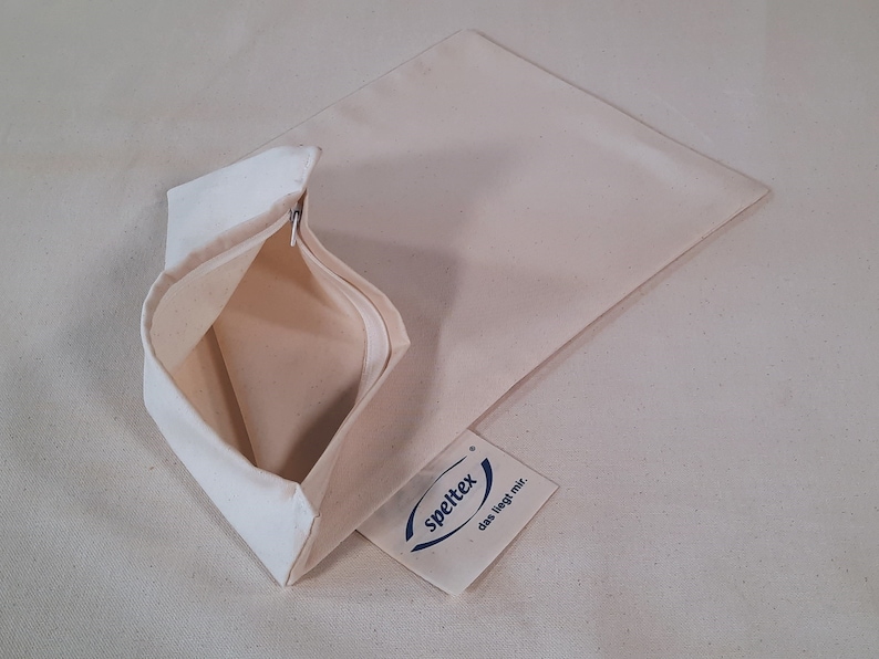 May include: A white cotton zippered pouch with a label that reads "spieltex das liegt mir."
