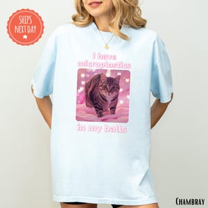a woman wearing a t - shirt with a picture of a cat on it
