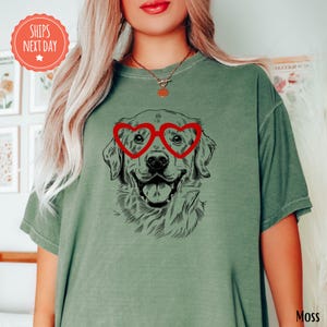 a woman wearing a green shirt with a dog wearing heart shaped glasses