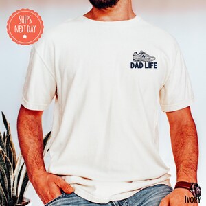 a man with a beard wearing a dad life t - shirt