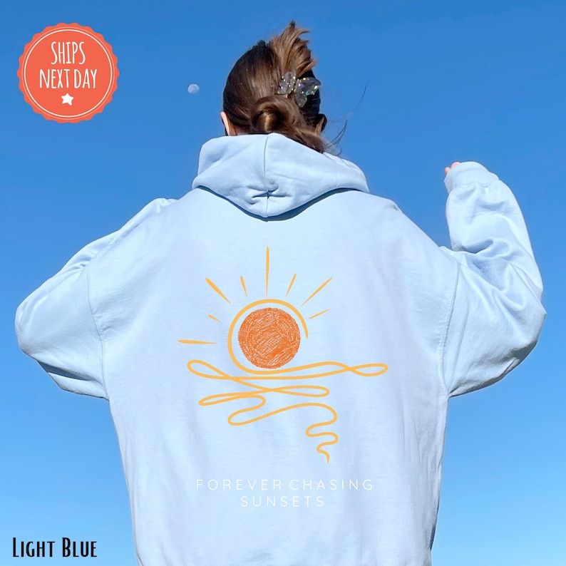 a woman wearing a white hoodie with a sun on it