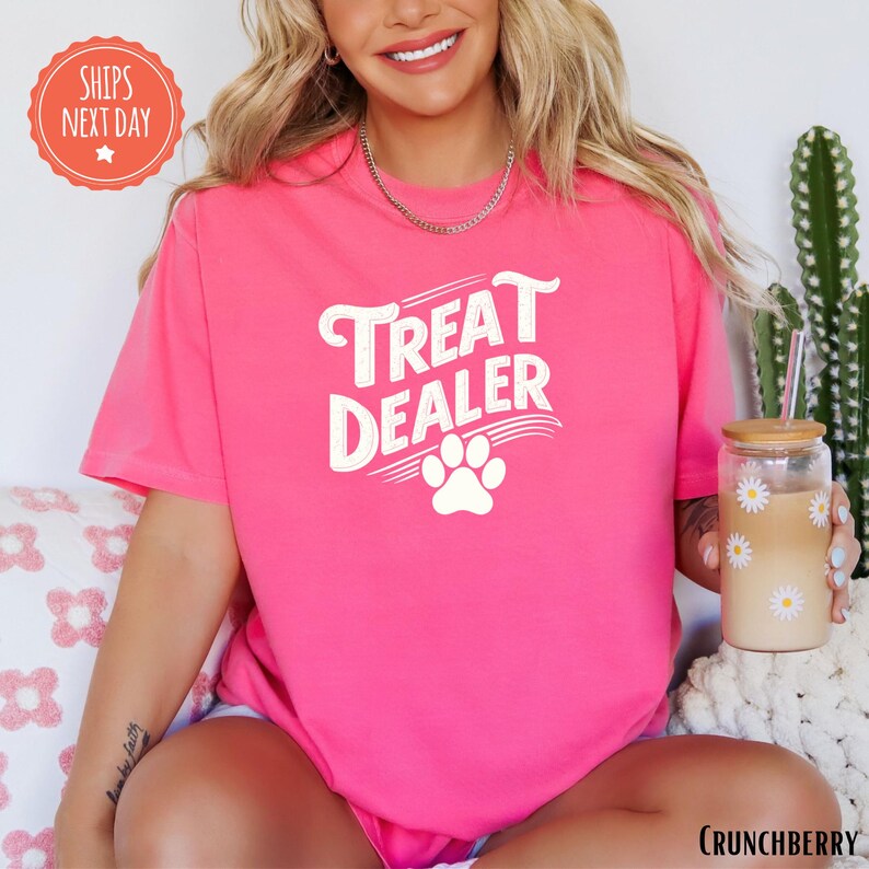 a woman wearing a pink shirt with a dog paw on it