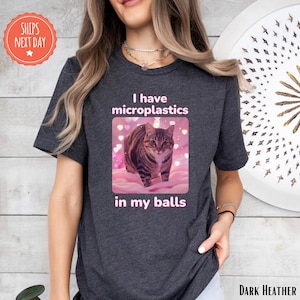 a woman wearing a t - shirt with a picture of a cat on it