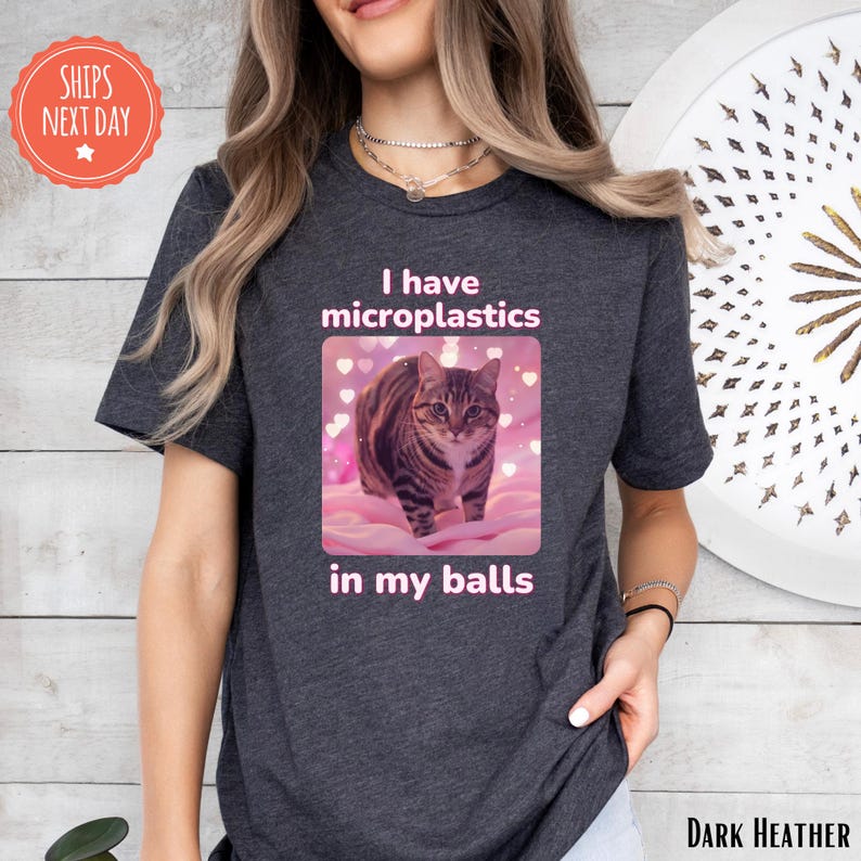 a woman wearing a t - shirt with a picture of a cat on it