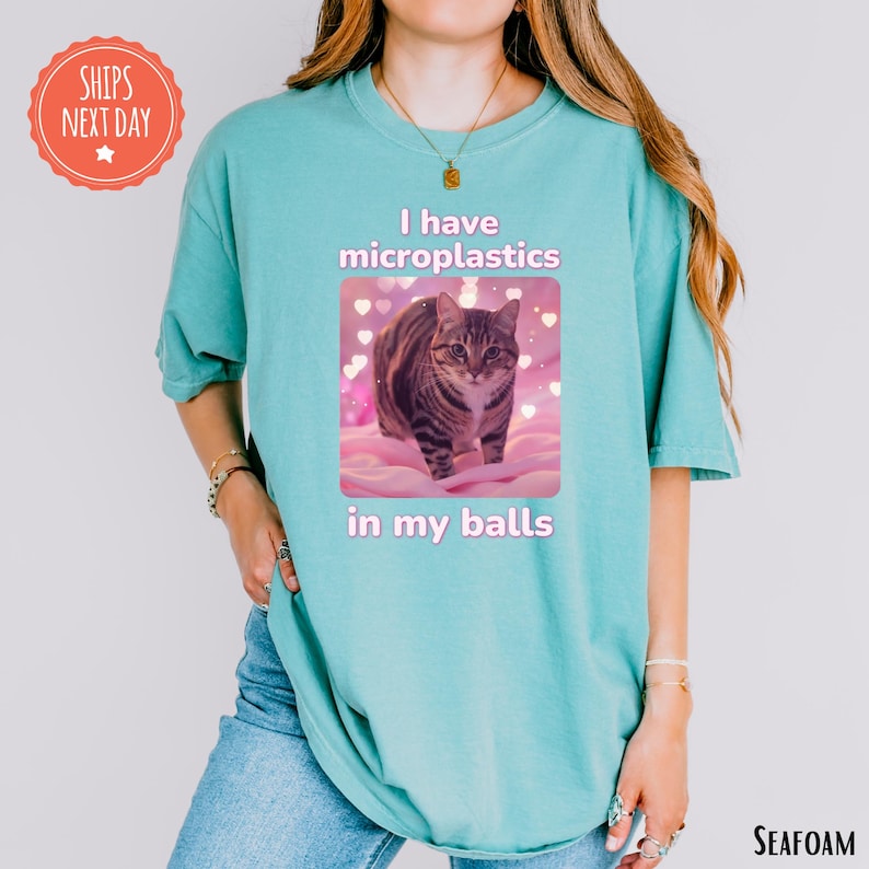 a woman wearing a t - shirt with a picture of a cat on it