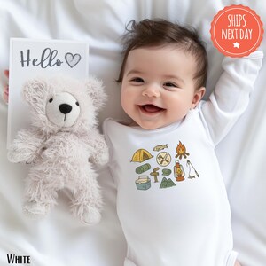 a baby is smiling next to a teddy bear