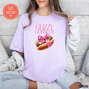 a woman wearing a pink shirt with a hot dog on it