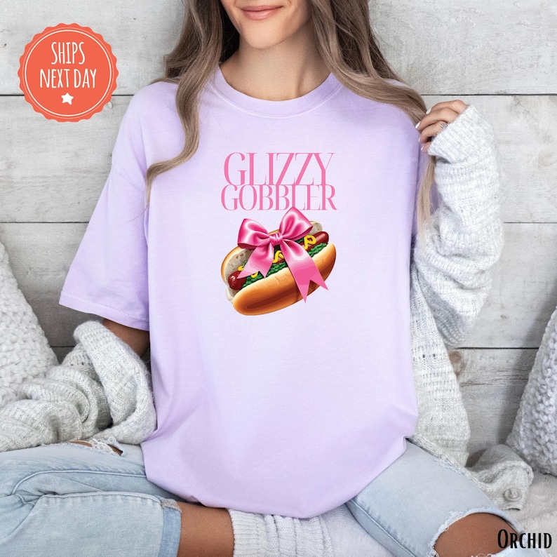 a woman wearing a pink shirt with a hot dog on it