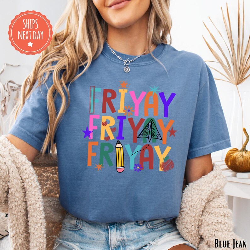 A woman wearing a blue t-shirt with a colorful graphic design that says "RIYAY FRIDAY" and includes various icons and illustrations.