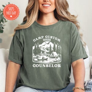 a woman sitting on a couch wearing a t - shirt