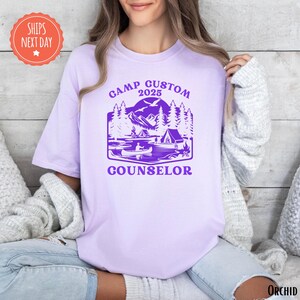 a woman wearing a purple t - shirt with the words camp custom and a picture