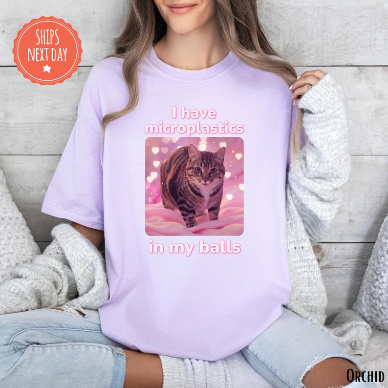 a woman wearing a t - shirt with a picture of a cat on it