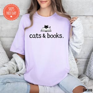 a woman wearing a t - shirt that says cats and books