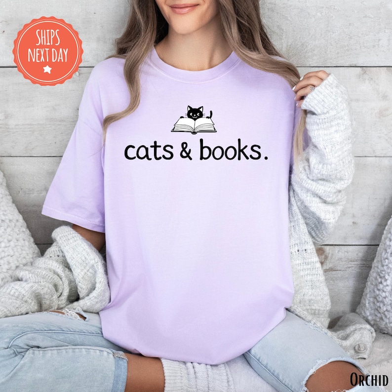 a woman wearing a t - shirt that says cats and books
