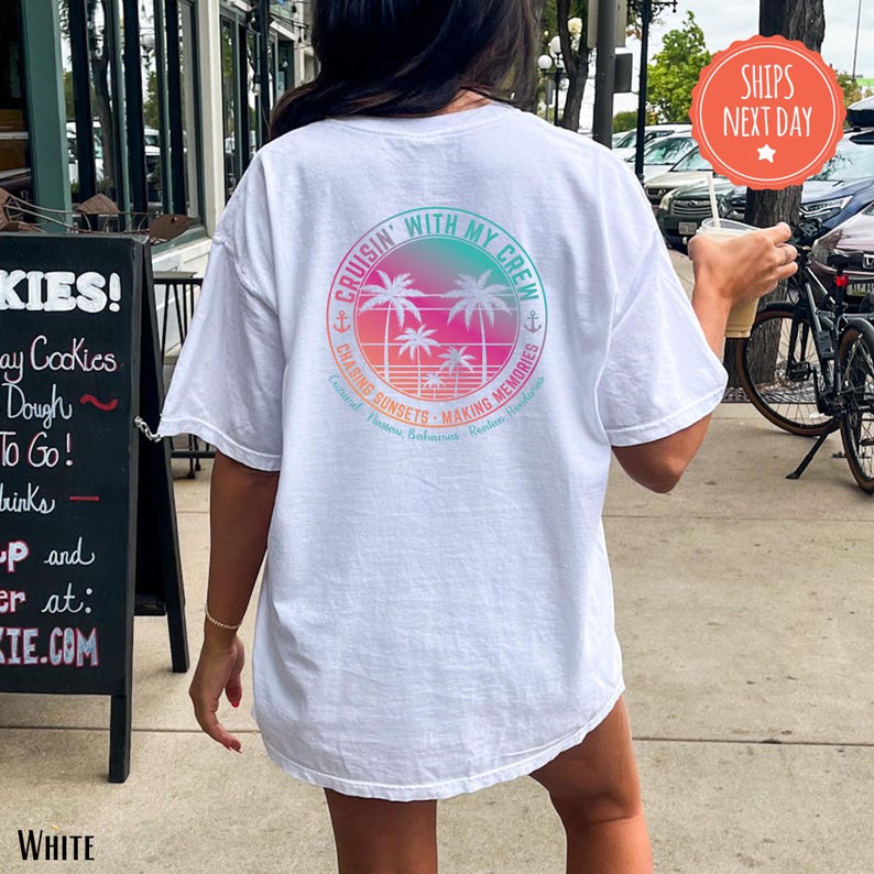 A person wearing a white t-shirt with a colorful graphic design on the back is walking on a sidewalk.