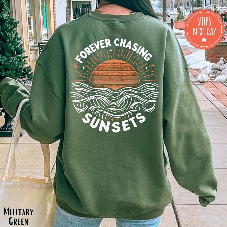 a woman wearing a green sweatshirt that says forever chasing sunsets