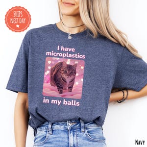 a woman wearing a t - shirt with a picture of a cat on it
