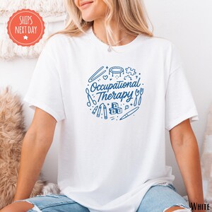 A woman wearing a white t-shirt with the text "Occupational Therapy" printed on it, sitting on a couch.