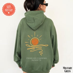 a woman wearing a green sweatshirt with a sun on it