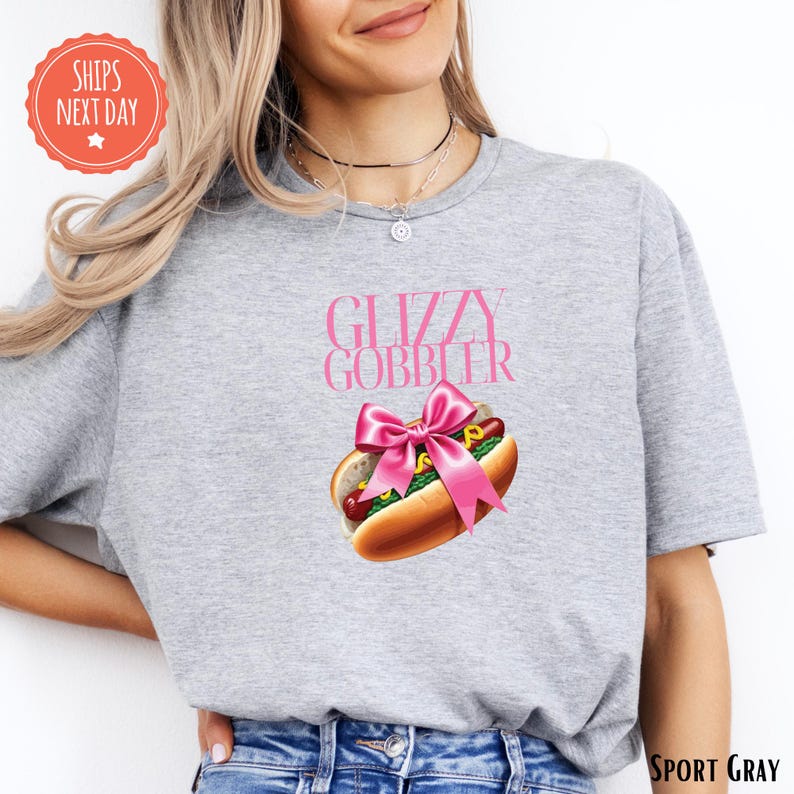 a woman wearing a gray shirt with a hot dog on it