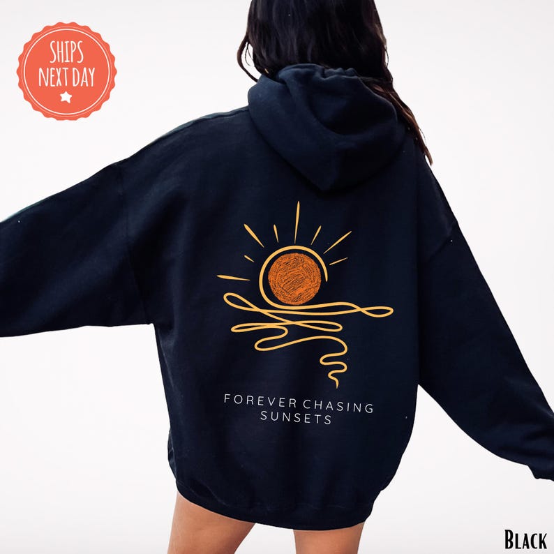 a woman wearing a black hoodie with a sun on it