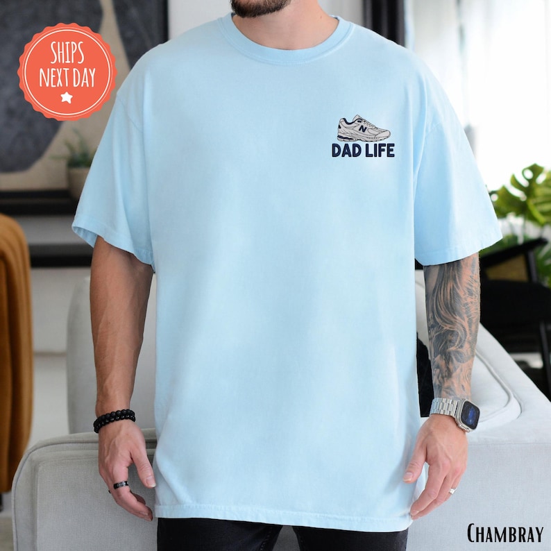 a man in a blue shirt is standing in a living room