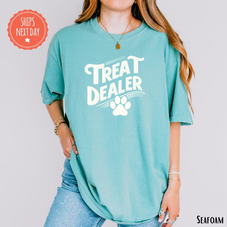 a woman wearing a teal t - shirt that says treat dealer