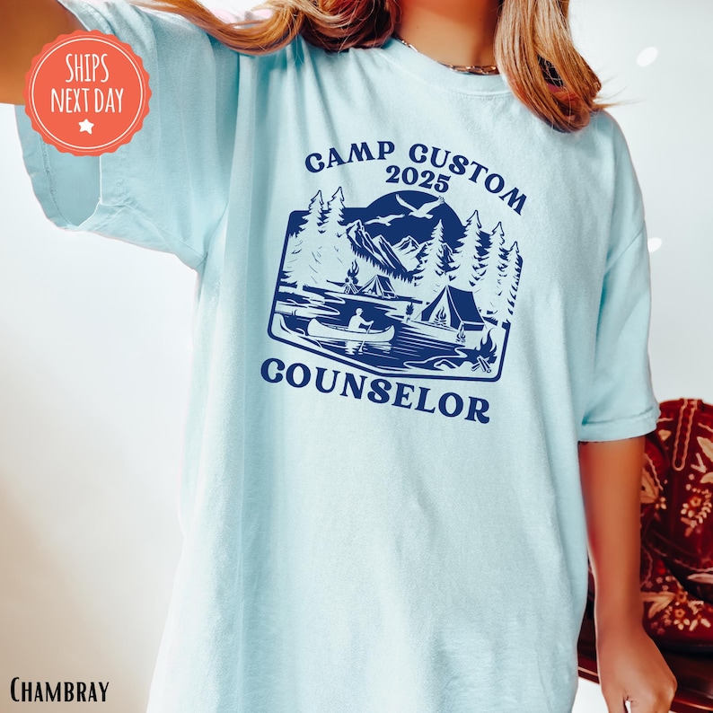 a woman wearing a blue shirt with a camper on it